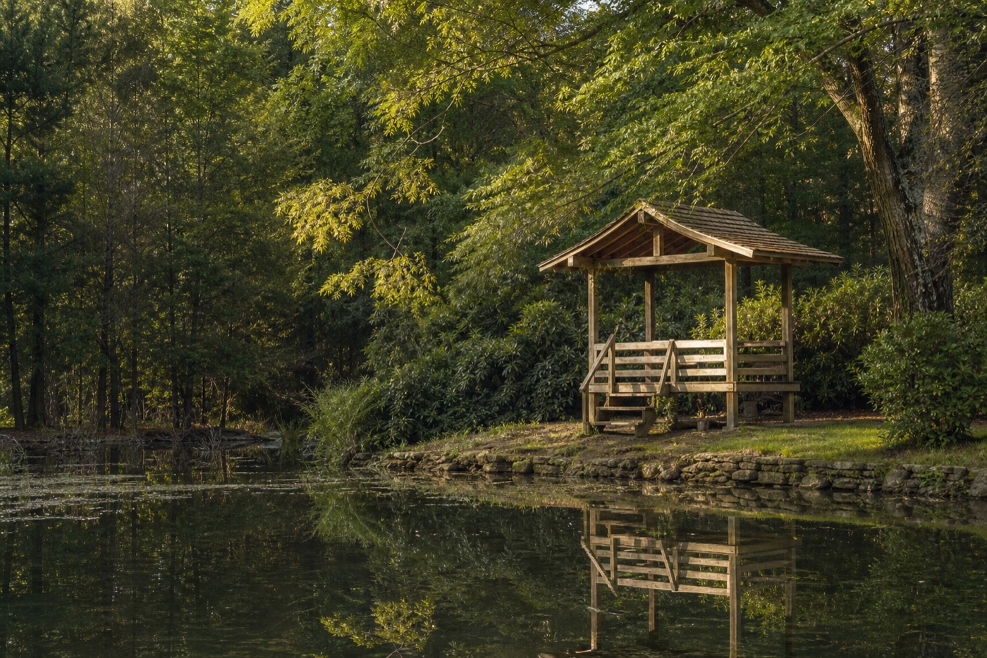 Atmospheric wooden gazebo beside a pond used as concept imagery